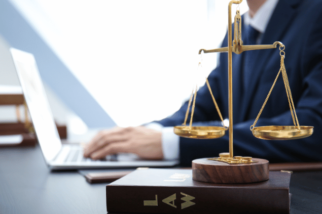 Balança da Justiça e Livro Jurídico na Mesa do Escritório do Advogado. 