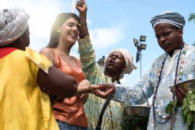 Imagem de filhos e filhas da cabocla jurema em um ritual com uma mulher devota.