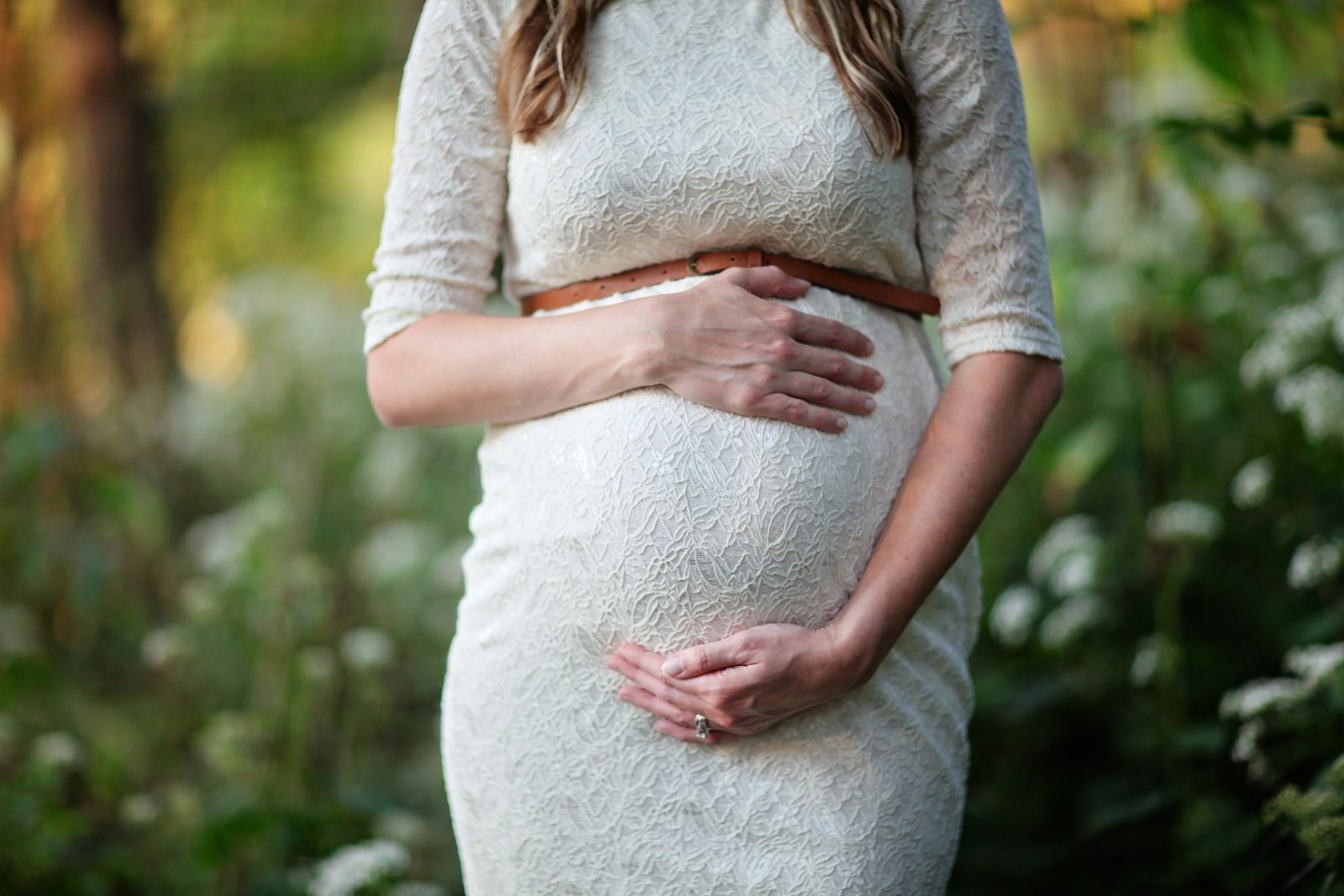 Mulher grávida com as mãos na barriga