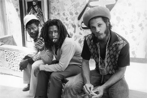 Membros do The Congos em foto antiga, sentados lado a lado.